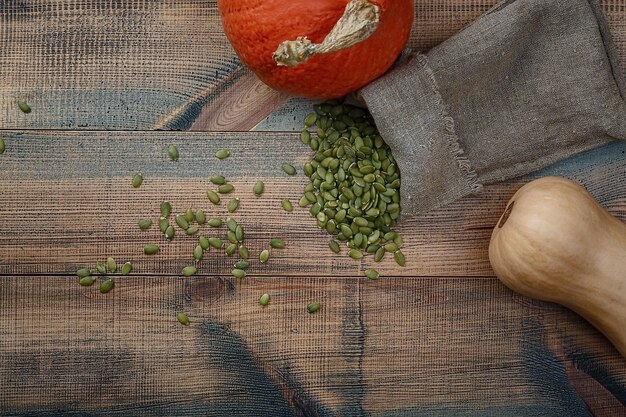 Zucche e semi di zucca su un tavolo di legno. vista dall'alto.