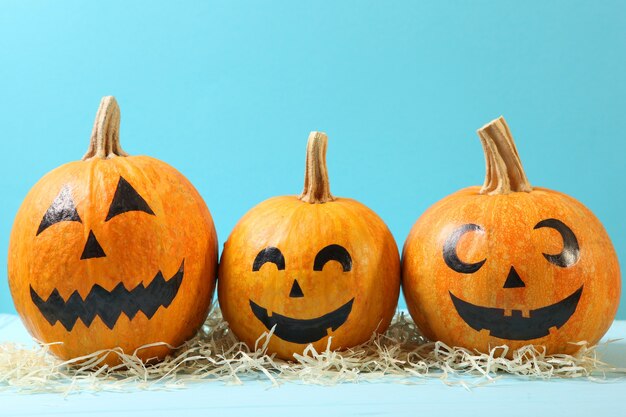 Pumpkins with painted faces on a colored background for halloween