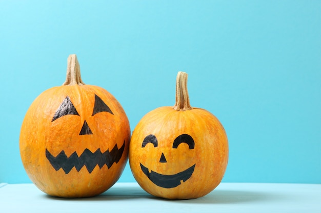 Pumpkins with painted faces on a colored background for halloween