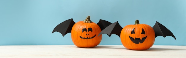 Pumpkins with smile and wings on blue background