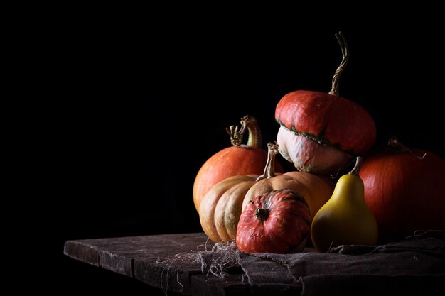 Pumpkins on wooden table in dark background