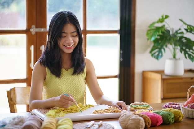 スタジオ ワーク ショップ デザイナーの職場で手作り趣味編み物を作るパンチ針アジア女性手作りクラフト プロジェクト DIY 刺繍コンセプト