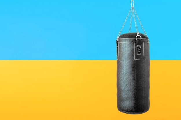 Punching bag hanging on colorful flag of Ukraine