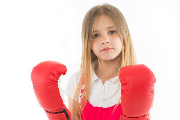 Punching Childhood development and health Success Adorable boxer isolated on white Fitness trainer Girl in red boxing gloves Little child in boxing pose Ready to fight Power and strength