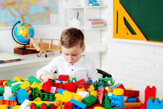 Pupil in class. Kid is learning in class on background of blackboard. Toys for preschool and kindergarten.