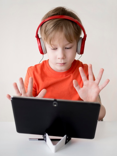 Photo pupil counting with his fingers and showing to the webcam