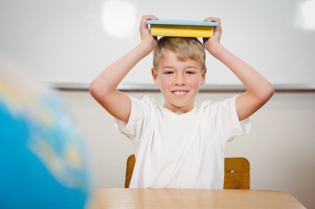 Pupil holding book over his head