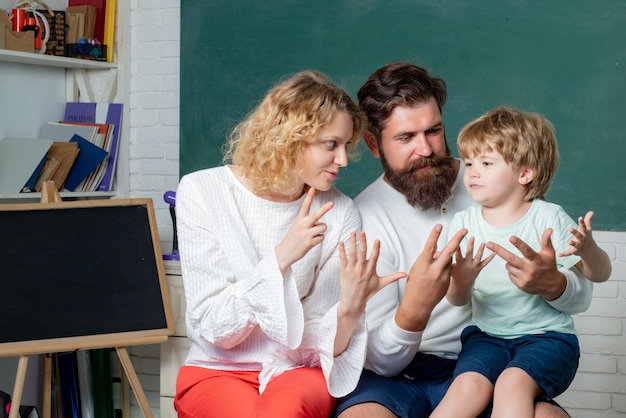 Pupil learning letters and numbers mathematics concept young couple helping his son to make homework