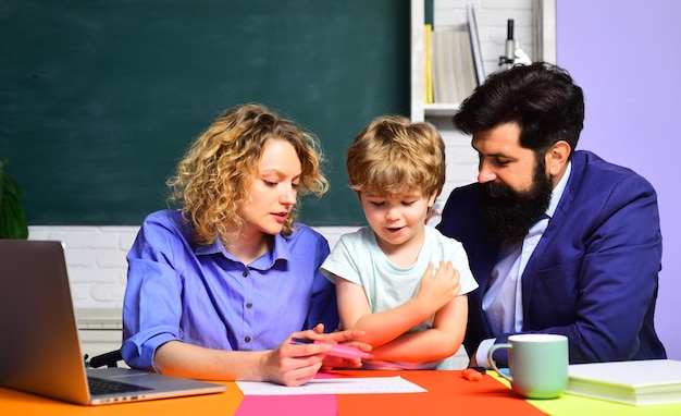 Pupil learning letters and numbers mother father and son together schooling little boy and his