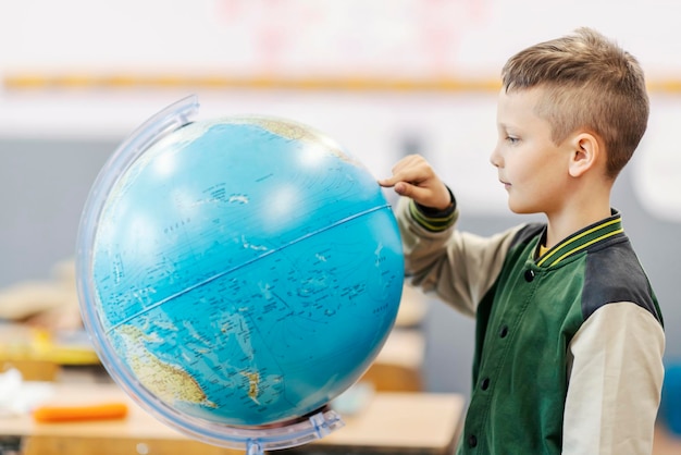 A pupil pointing at globe on geography class