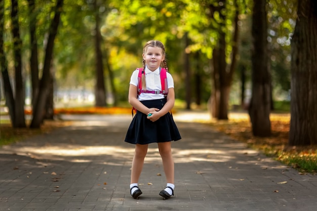 小学校の生徒。屋外のバックパックを持つ少女。レッスンの始まり。秋の初日。