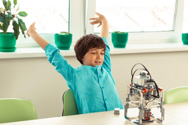 Pupil stretching himself resting after building his school project out of construction set