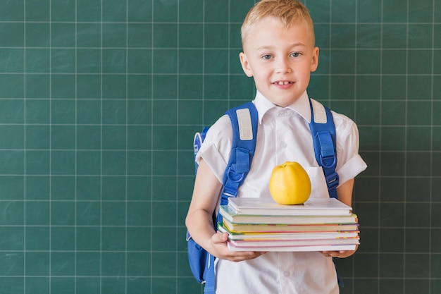 Foto allievo con zaino e libri di testo in classe