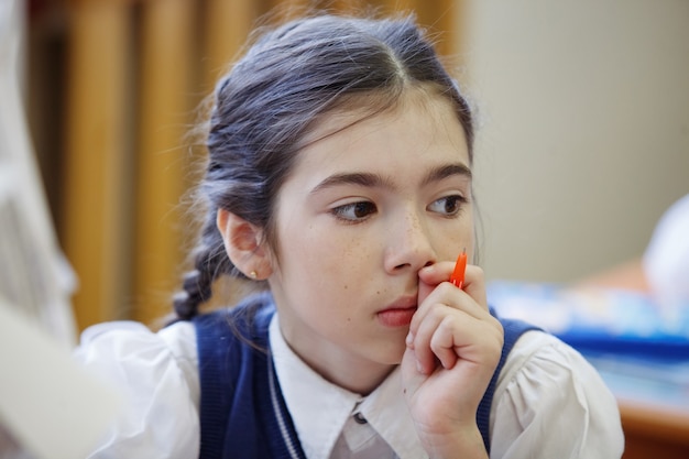 Gli alunni al banco pensano e decidono il compito a scuola. istruzione primaria, formazione e concetto di persone