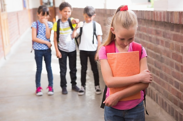 Pupils friends teasing a pupil alone 