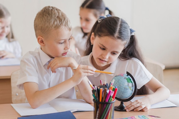 Pupils looking at globe together