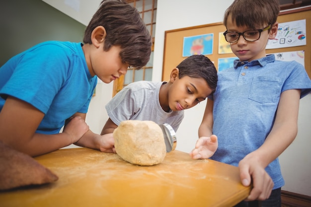 Pupils looking at rock with magnifying glass