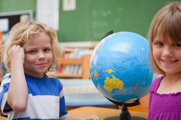 Pupils posing in front of a globe