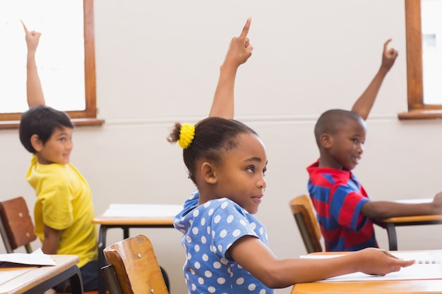 Photo pupils raising hand in classroom