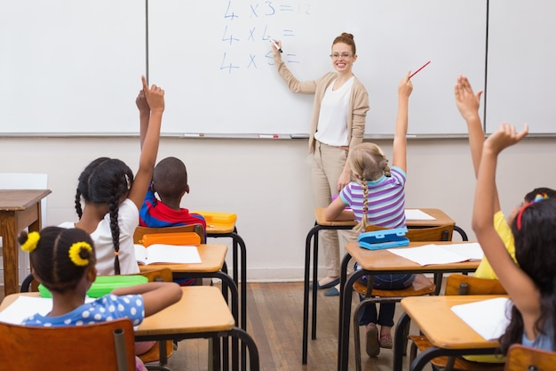 Pupils raising hand in classroom 