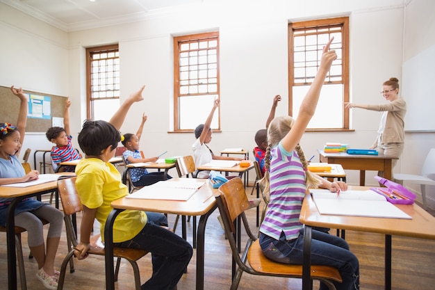 Pupils raising hand in classroom 