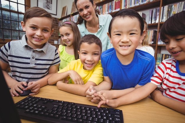 Pupils and teacher in the library using computer