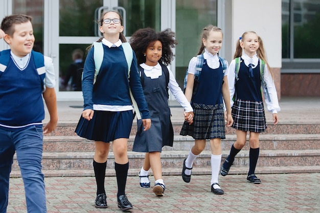 Pupils in uniform and with backpacks go to school.