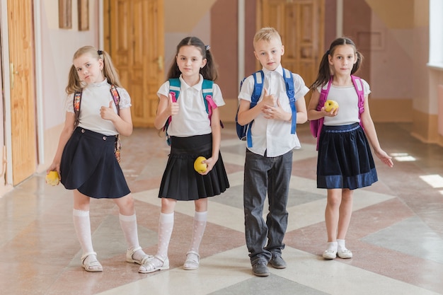 Photo pupils with apples gesturing thumb-up