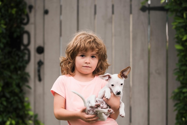 Puppies en kind buiten jongen draagt kleine hond tedere emoties