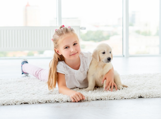 Puppy of retriever and little girl