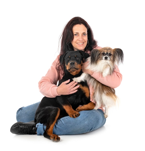 puppy rottweiler papillon and woman in front of white background