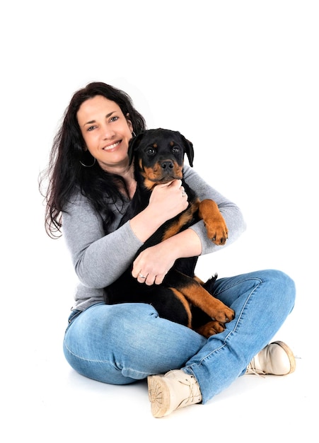 Puppy rottweiler and woman in front of white background