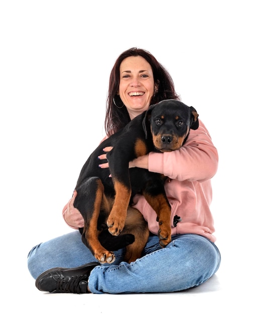 puppy rottweiler and woman in front of white background