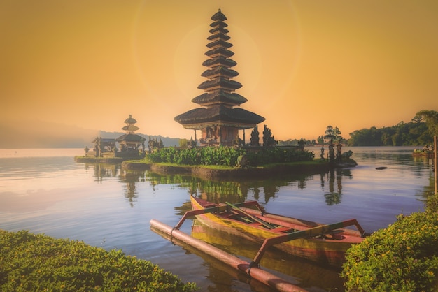 Pura Ulun Danu Bratan, Hindu temple with boat on Bratan lake landscape at sunrise in Bali, Indonesia.