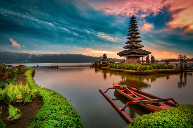 Photo pura ulun danu bratan, hindu temple with boat on bratan lake landscape at sunrise in bali, indonesia.