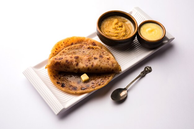 Puran Poli, also known as Holige, is an Indian sweet flatbread consumed mostly during Holi festival. Served in a plate with pure Ghee over colourful or wooden background