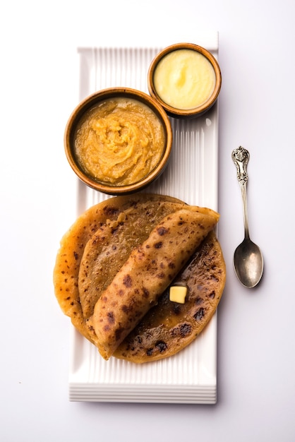 Puran Poli, ook bekend als Holige, is een Indiase zoete flatbread die meestal wordt geconsumeerd tijdens het Holi-festival. Geserveerd in een bord met pure Ghee op een kleurrijke of houten ondergrond