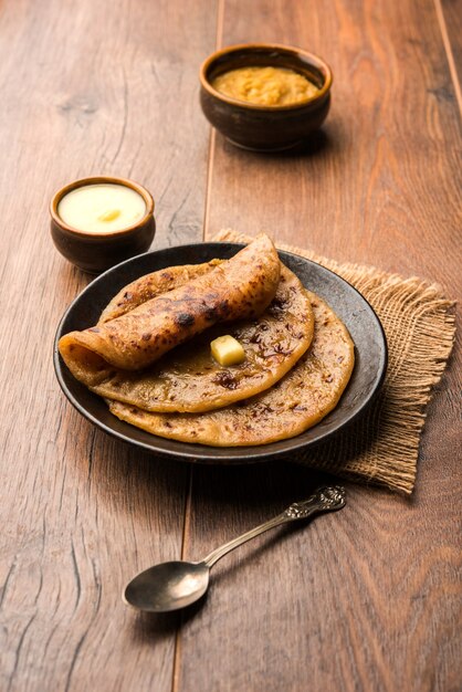 Puran Poli, ook bekend als Holige, is een Indiase zoete flatbread die meestal wordt geconsumeerd tijdens het Holi-festival. Geserveerd in een bord met pure Ghee op een kleurrijke of houten ondergrond