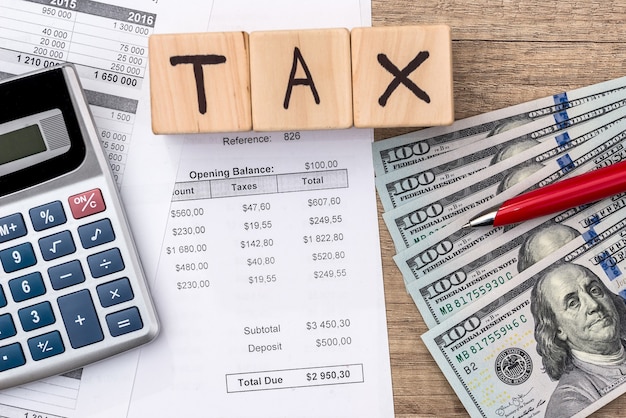 Purchase order, dollar, wooden cubes with text tax, pen and calculator