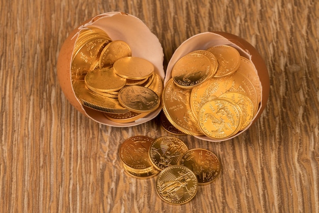 Pure gold coins in eggshell illustrating nest egg