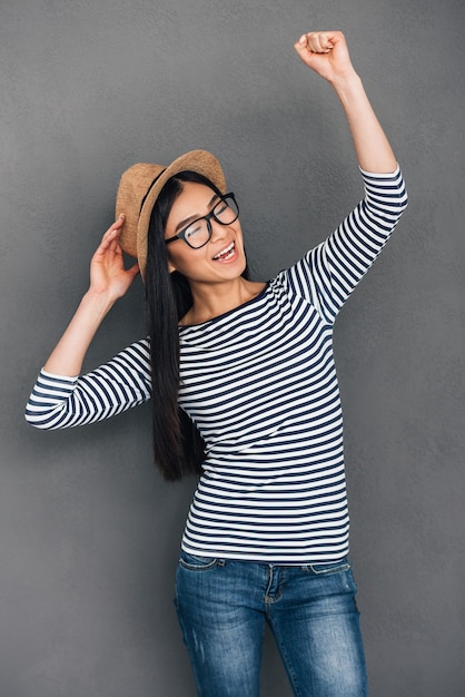 Pure joy. Beautiful young Asian woman in hat gesturing and looking happy