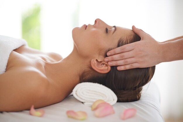 Pure relaxation Side view of a young woman receiving a head massage at a spa