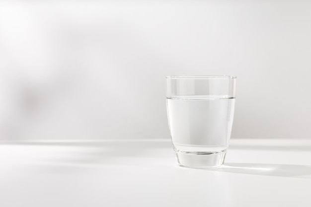 Pure water in the glass is on the white wooden table