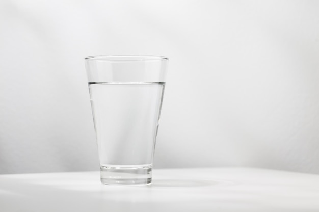 Pure water in the glass is on the white wooden table