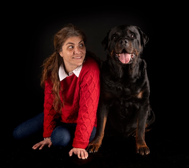 Purebred rottweiler and woman isolated on black