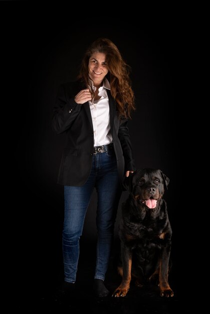 Purebred rottweiler and woman isolated on black