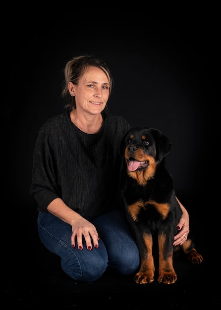 Purebred rottweiler and woman isolated on black