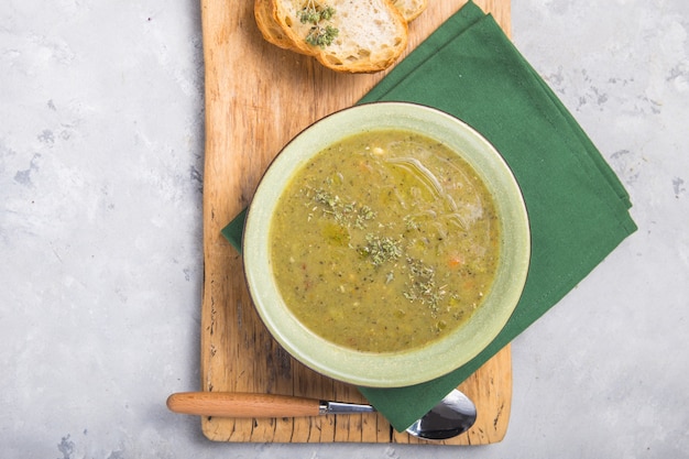 Puree van broccolisoep met geserveerd met geroosterde plakjes stokbrood en folive olie op een houten bord uitzicht van bovenaf, flatlay, kopie ruimte