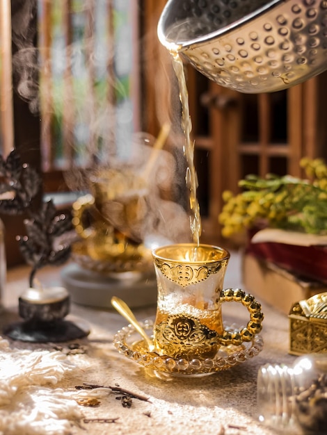 Puring hot tea in transparant glass on the table