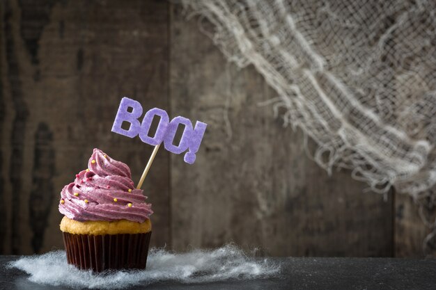 Purper Halloween cupcake op zwarte achtergrond. Kopieer ruimte